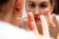 Closeup, young woman with a contact lens looking in mirror Royalty Free Stock Photo