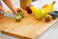 Closeup on young woman cutting kiwi Royalty Free Stock Photo