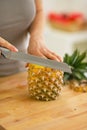 Closeup on young woman cutting pineapple Royalty Free Stock Photo