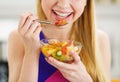 Closeup on young woman eating fresh fruits salad in kitchen Royalty Free Stock Photo