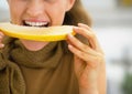 Closeup on young woman eating melon in kitchen