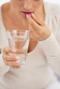 Closeup on young woman eating pill Royalty Free Stock Photo