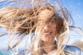 Closeup of young woman face covered with flying hair in windy day