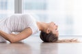 Closeup of young woman in Fish pose against floor window Royalty Free Stock Photo