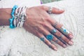 closeup of young woman hand with lot of boho style jewrly, rings and bracelets outdoor