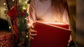 Closeup of young woman opens big red box with Christmas present. Winter holidays, celebrating New Year. Royalty Free Stock Photo