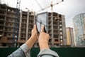 Closeup of young woman posing on building site and using digital Royalty Free Stock Photo