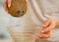 Closeup on young woman pouring coconut milk in plate Royalty Free Stock Photo