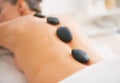 Closeup on young woman receiving hot stone massage. rear view Royalty Free Stock Photo