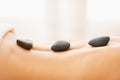 Closeup on young woman receiving hot stone massage Royalty Free Stock Photo