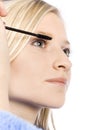 Closeup of young woman's face putting mascara