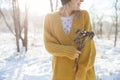Closeup of young woman`s hands holding dry flowers on a sunny winter park background. Girl smiling outdoors. Winter and holidays Royalty Free Stock Photo