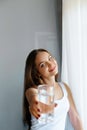 Closeup young woman show glass of water. Portrait of happy smiling female model holding transparent glass of water.Healthy lifesty Royalty Free Stock Photo