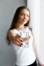 Closeup young woman show glass of water. Portrait of happy smiling female model holding transparent glass of water.Healthy lifesty Royalty Free Stock Photo