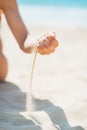 Closeup on young woman sitting on beach and playing with sand Royalty Free Stock Photo