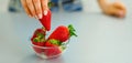 Closeup on young woman taking strawberry