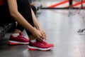 Closeup young woman tying shoelace with hands for jogging in fitness gym sport club.