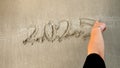 Closeup of young woman writing new year 2025 on the wet sand at sea beach Royalty Free Stock Photo