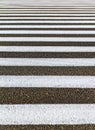 Closeup zebra pedestrian crossing on the asphalt road. White stripes on black road