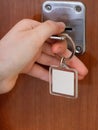 Closing house door by key with blank keychain Royalty Free Stock Photo