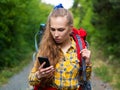 Closse-up portrait of a woman, who lost in forest. She using mobile GPS map. Royalty Free Stock Photo