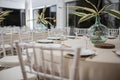 Closuep shot of tropical palm leaves in glass vases on the empty tables in a restaurant Royalty Free Stock Photo