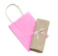 Cloth bundle and pink paper bag isolated on white