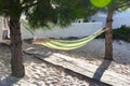 Cloth hammock hung between two pine trees at the entrance of a house on the Portuguese coast Royalty Free Stock Photo