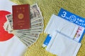 Cloth masks, leaflet and 100,000 yen in cash with passport on Japan flag and golden paper.