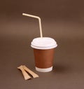 Clotheded take-out coffee with cup holder on brown background. Royalty Free Stock Photo