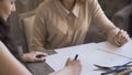 Clother designers woman creates a sketch on the paper to her client in tailor studio