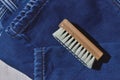 A clothes brush lies on folded jeans. cose up