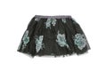 Clothes for children. Close-up of a beautiful black girl skirt with colorful pattern on black lace. Children spring and summer