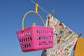 Clothes and clothespins in a pink basket hanging from clothesline Royalty Free Stock Photo