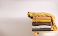 Clothes Concept. Stack of Clothing by the White Wall. Organic Cotton