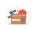 Clothes donation. Cardboard box full of different things. Volunteering and social care concept. Support for poor people