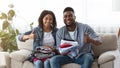 Clothes For Donation. Happy Black Couple Holding Clothing And Showing Thumbs Up