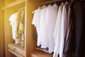 Clothes hang on a shelf in a designer clothes store, Modern closet with row of clothes hanging in wardrobe, Vintage rooms Royalty Free Stock Photo