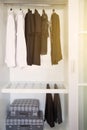 Clothes hang on a shelf in a designer clothes store, Modern closet with row of clothes hanging in wardrobe, Vintage rooms Royalty Free Stock Photo