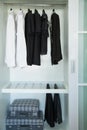 Clothes hang on a shelf in a designer clothes store, modern closet with row of cloths hanging in wardrobe, vintage rooms Royalty Free Stock Photo