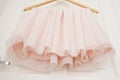 Clothes hanger with pink girl tutu dress isolated on the white door. Fashion, baby clothes. Royalty Free Stock Photo