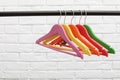 Clothes hangers on metal rail against wall background