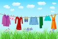 Clothes hanging on clothesline. Laundry hang on rope to dry on blue sky and meadow background.