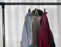 Clothes hanging on hangers, on a metal rail, blurred background. Royalty Free Stock Photo
