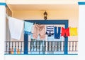 Clothes hanging on a washing line on a bright modern style blue and white balcony.
