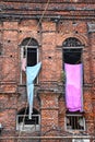 Clothes are hanging from the windows of a red brick wall vintage building Royalty Free Stock Photo