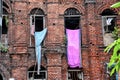 Clothes are hanging from the windows of a red brick wall vintage building Royalty Free Stock Photo