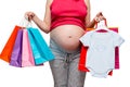 Clothes for her son and other purchases in the hands of a pregnant woman, belly closeup Royalty Free Stock Photo