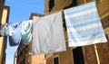 clothes hung out to dry in the sun with sheets and pillowcases in a narrow alley