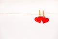 Clothes pegs and two red paper hearts on rope isolated on white background. Royalty Free Stock Photo